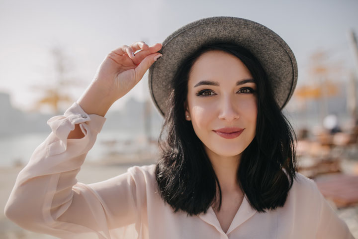 positive brunette woman in hat